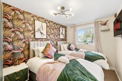 two beds in a room with a wall mural at Stunning House in Bristol - Hot Tub - Sleeps 10 in Bristol