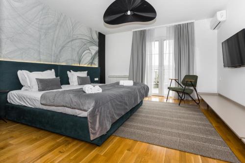 - une chambre avec un grand lit et un ventilateur noir dans l'établissement Art of Living luxury suite, à Sarajevo