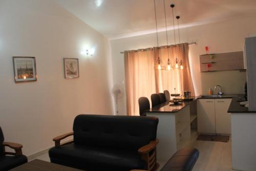 a living room with a table and a kitchen at Two Seas Residence in Ooty