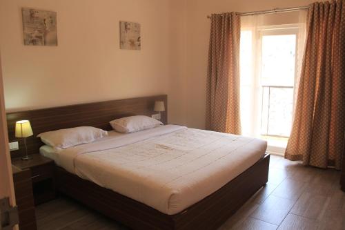 a bedroom with a large bed with a window at Two Seas Residence in Ooty