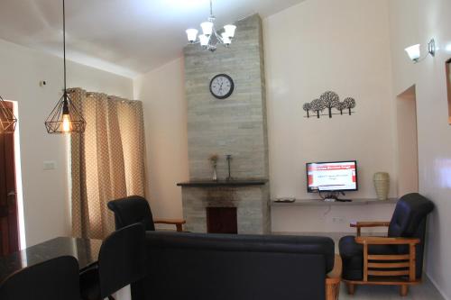 a living room with a fireplace and a clock on the wall at Two Seas Residence in Ooty