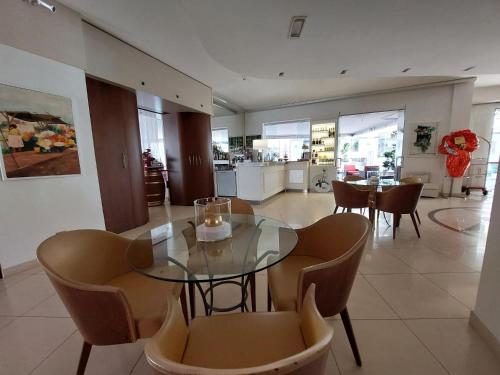 a dining room with a glass table and chairs at Hotel Aida in Alassio