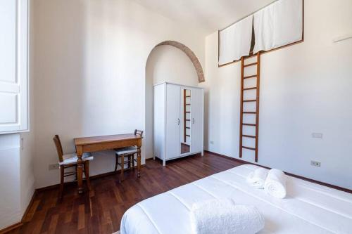 sypialnia z łóżkiem, stołem i biurkiem w obiekcie [Duomo] Elegante Appartamento we Florencji