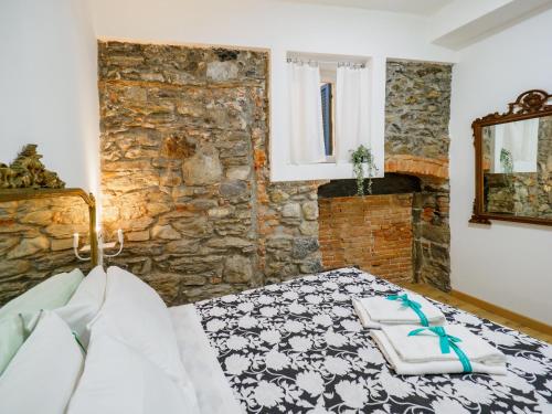 a bedroom with a bed and a stone wall at Specciu Cozy Apartment in Vernazza