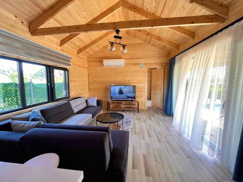 a living room with a couch and a tv at KARYA TREE HOUSE in Dalaman