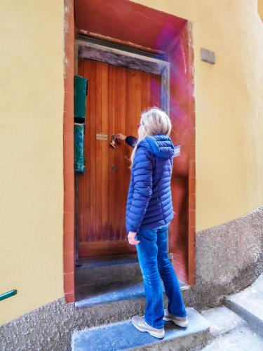 a young girl standing in front of a wooden door at Specciu Cozy Apartment in Vernazza