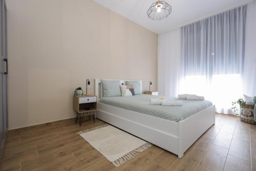 Un dormitorio blanco con una cama grande y una ventana en North Views Luxury Apartment, en Subotica
