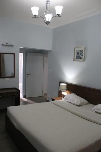 a bedroom with a large bed and a television at Two Seas Residence in Ooty