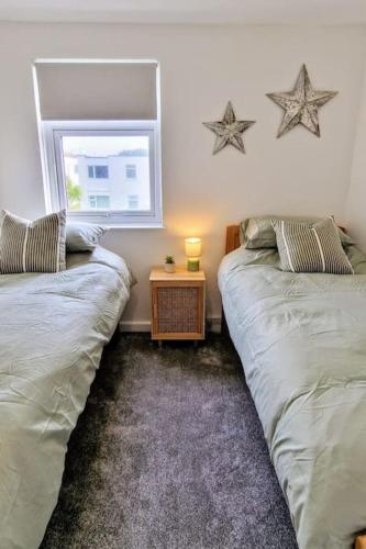 two beds in a room with stars on the wall at Eastern Green Apartment, Penzance - Beach access and Parking in Penzance