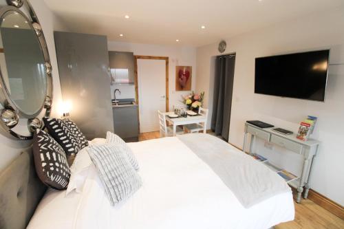 彭里斯的住宿－Hillcrest Studio, Penrith，卧室配有一张带镜子的白色大床