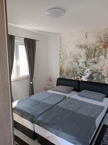 a bedroom with a bed and a painting on the wall at Holiday Home Racic in Bihać
