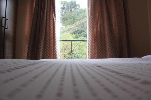a bedroom with a white bed and a window at Two Seas Residence in Ooty