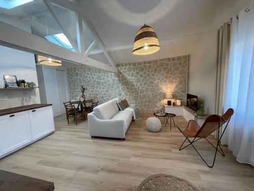 sala de estar con sofá blanco y sillas en L'escapade, en Milly-la-Forêt