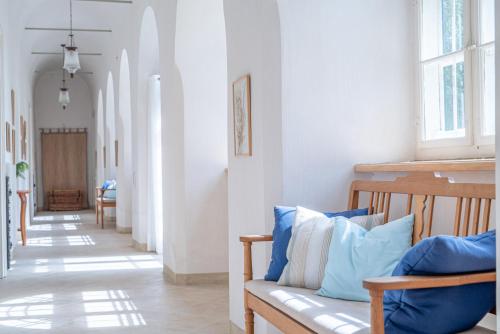 a hallway with a couch with blue and white pillows at Svastics kúria in Szentgáloskér