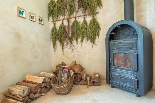 a blue stove sitting next to a pile of wood at Svastics kúria in Szentgáloskér