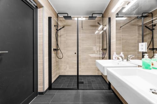 a bathroom with two sinks and a shower at Nordica Resort Florø in Florø