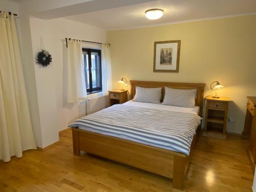a bedroom with a bed with two night stands and a window at Pension Wok in Český Krumlov