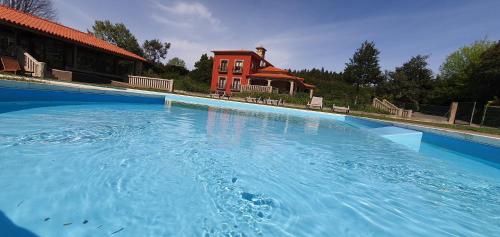 a large pool of water in front of a house at Villam Natura & Spa in Vila Nova de Famalicão