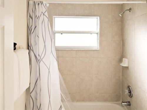 a bathroom with a shower curtain and a window at 4 Bed 428 in Davenport