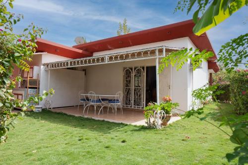 a house with a patio and a yard at Villa Jacaranda dans Copropriété face au Supermarché Carrefour de Saly avec Piscine Privée et H24 Gardiennage et Parking Prive in Sali Tapé