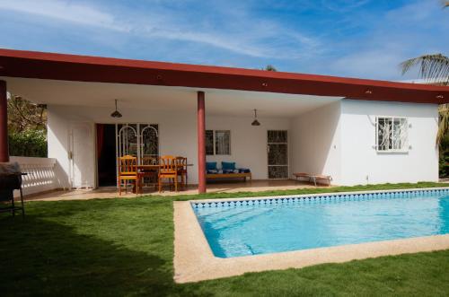 a house with a swimming pool in the yard at Villa Jacaranda dans Copropriété face au Supermarché Carrefour de Saly avec Piscine Privée et H24 Gardiennage et Parking Prive in Sali Tapé