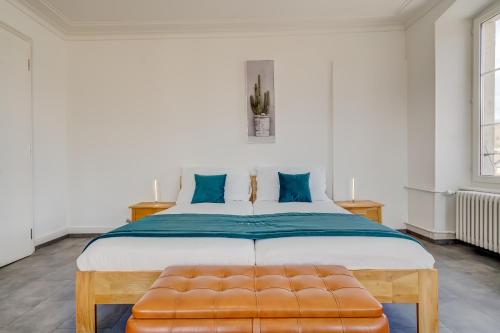 a bedroom with a large bed with blue pillows at The 5 Continents II by Stay Swiss in Porrentruy