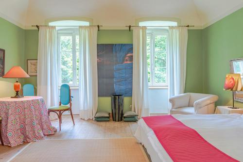 um quarto com uma cama, uma mesa e janelas em Svastics kúria em Szentgáloskér