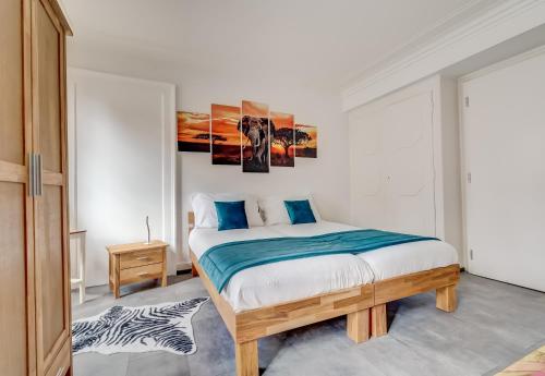a bedroom with a large bed with blue pillows at The 5 Continents II by Stay Swiss in Porrentruy
