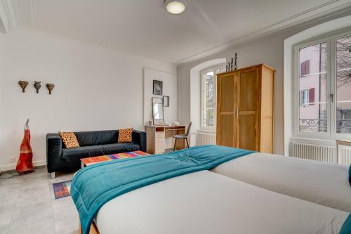a bedroom with a bed and a living room at The 5 Continents II by Stay Swiss in Porrentruy
