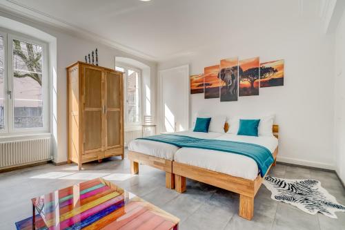 a bedroom with a bed and a wooden cabinet at The 5 Continents II by Stay Swiss in Porrentruy