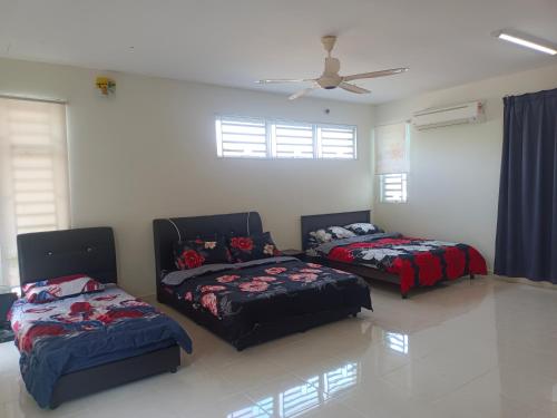 a bedroom with two beds and a ceiling fan at Pro-Qaseh Room Stay , Darulaman Lake Home in Jitra