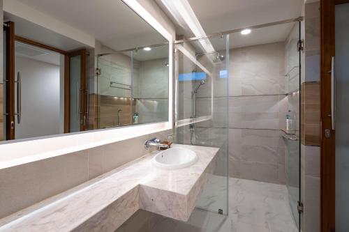 uma casa de banho com um lavatório e uma cabina de duche em vidro. em Samui Privacy Modern Luxury Seaview Natural Rainforest Infinity Pool Villa em Koh Samui
