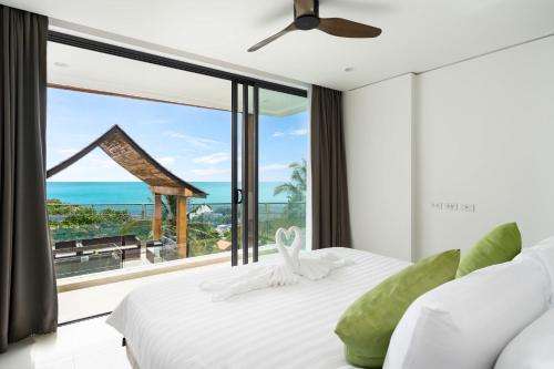 a bedroom with a view of the ocean at Samui Privacy Modern Luxury Seaview Natural Rainforest Infinity Pool Villa in Koh Samui 