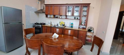 a kitchen with a wooden table and a refrigerator at House by the sea in Shekvetili