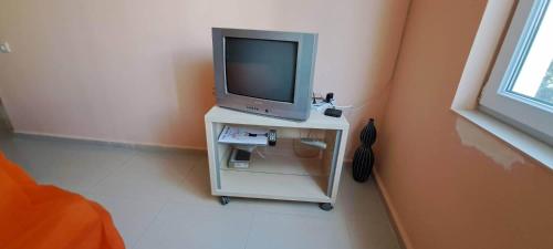 a tv on a white table in a room at House by the sea in Shekvetili