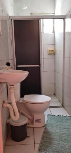 a bathroom with a pink toilet and a sink at Quartos privativo frente mar com banheiro compartilhado in Maragogi