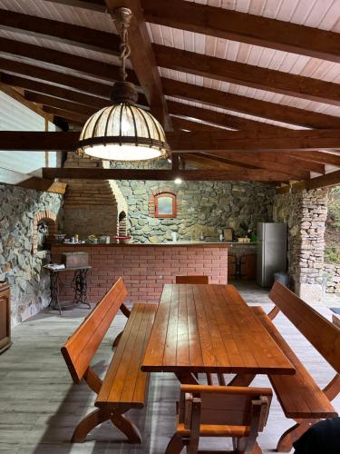 a dining room with a wooden table and benches at Casa de Piatra in Strungari