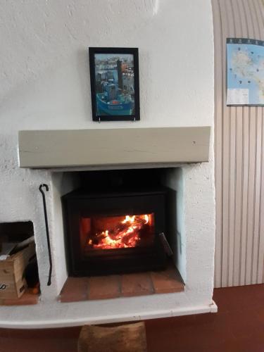 a fireplace with a fire inside of it at Résidence Sables d'Or Accès direct plage in La Guérinière