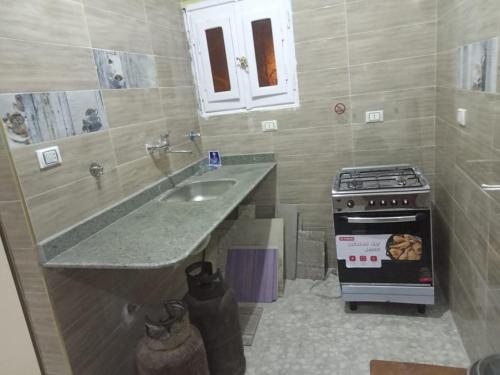 a kitchen with a sink and a stove at Ikea flat 5 in Hurghada