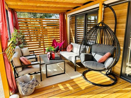 a screened in porch with a swing and a table at Iris Holiday Homes - Camping park Soline in Biograd na Moru