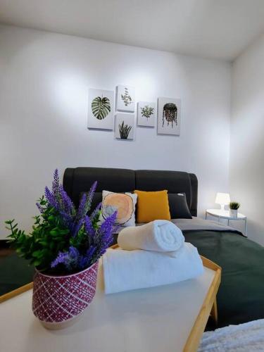 a room with a couch and a table with towels and flowers at Symphony Tower 3BR High Floor 100mbps Wi-Fi Netflix in Cheras