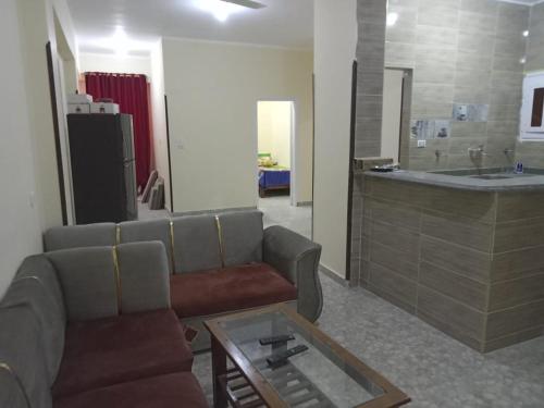 uma sala de estar com um sofá e uma mesa em Ikea flat 4 em Hurghada