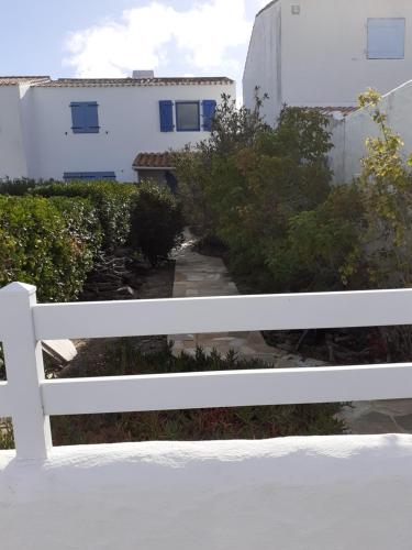 a white bench in front of a white building at Résidence Sables d'Or Accès direct plage in La Guérinière