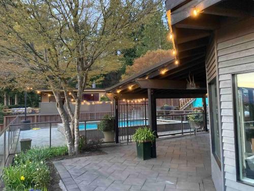 a house with a patio with a tree and a pool at The Lions Self Contained Suite, Shared Pool, Hot Tub, Views in North Vancouver