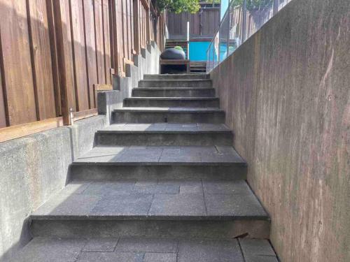 a set of concrete stairs next to a wall at The Lions Self Contained Suite, Shared Pool, Hot Tub, Views in North Vancouver