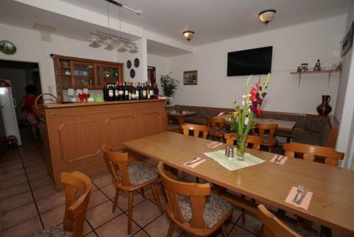 restauracja z drewnianymi stołami i krzesłami oraz bar w obiekcie Pension Döppert w Norymberdze