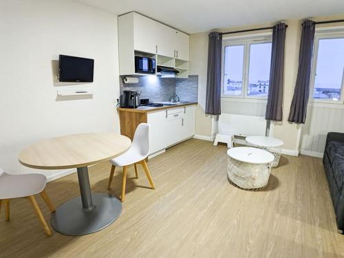 Il comprend un petit salon avec une table et une cuisine. dans l'établissement Studio Linois, à Brest