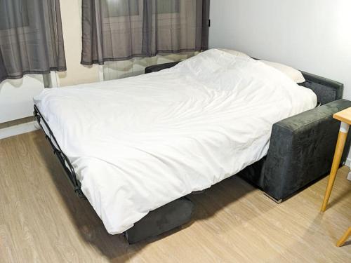 - un lit avec une couverture blanche dans l'établissement Studio Linois, à Brest