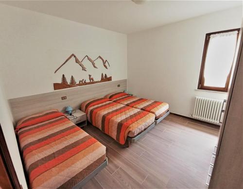 una camera da letto con due letti e una finestra di Appartamento Girasole a Ledro