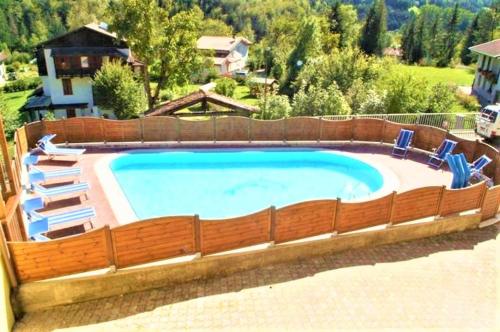 una gran piscina con sillas alrededor en Appartamento Girasole en Ledro